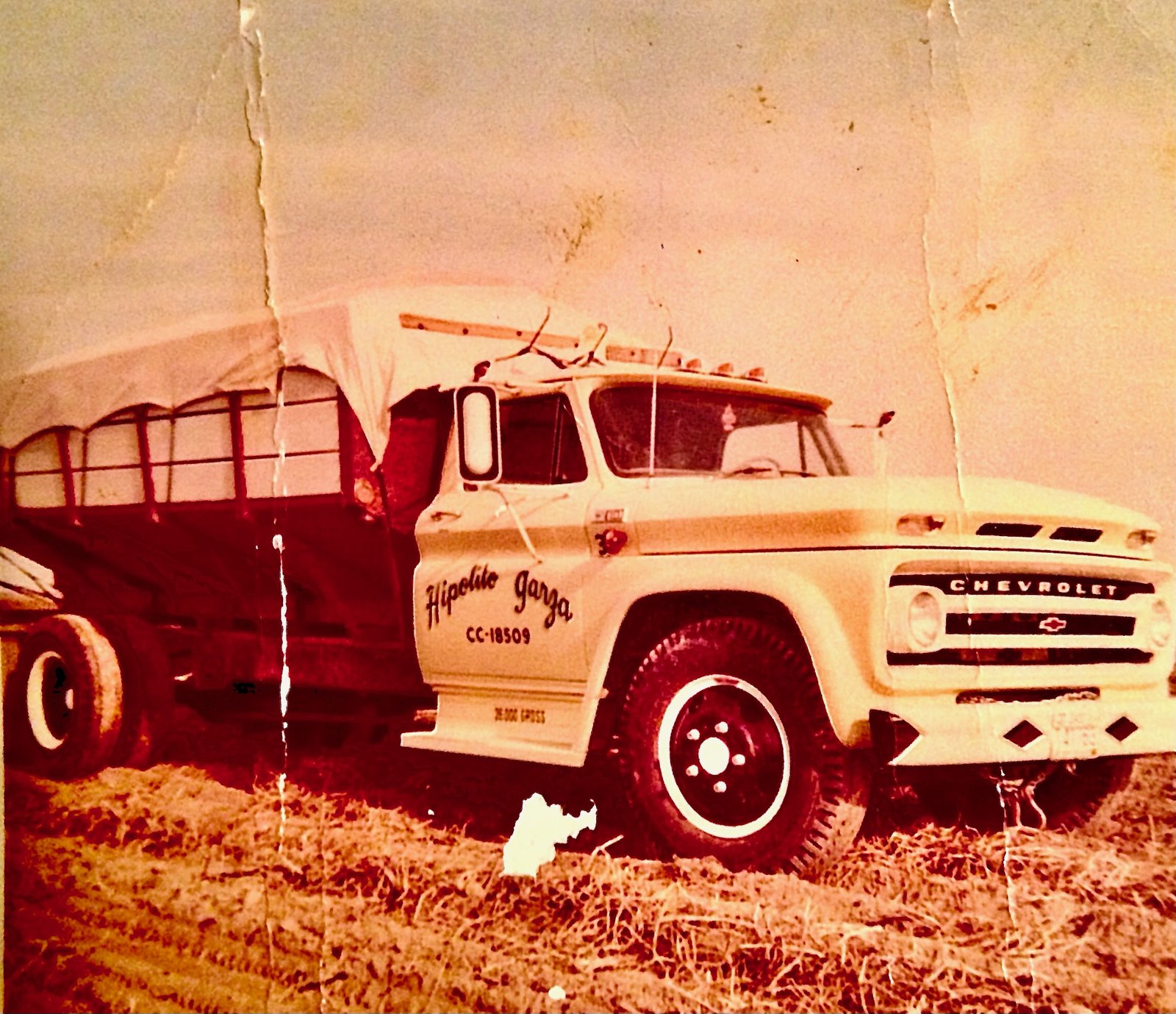 Hipolito Garza's first truck, a Chevrolet with his name on the door, in an Othello, Washington field
